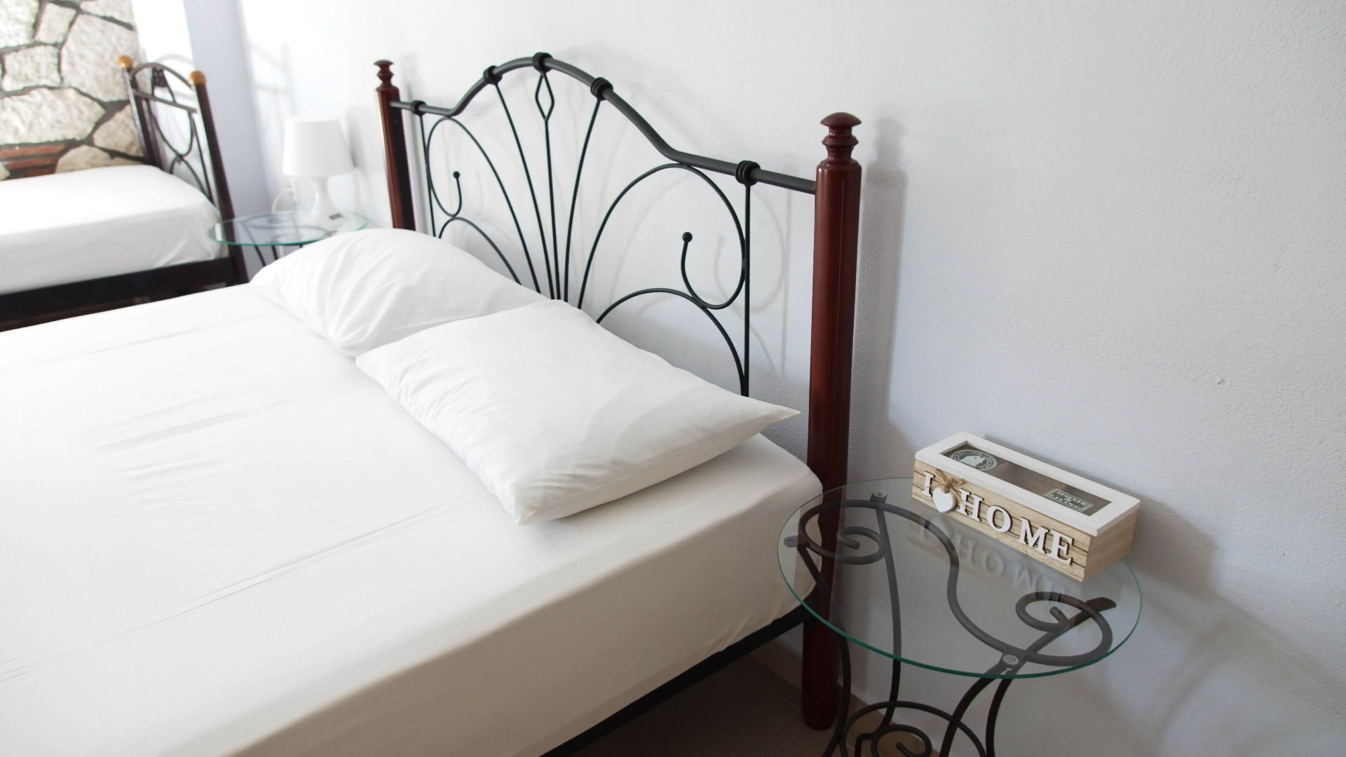 A double bed and a small nightstand with a box that says 'home'.